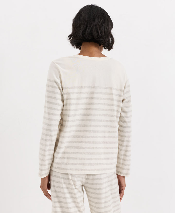 A person shown from the back wearing a long-sleeve striped top and matching striped pants in a light cream and beige colorway, against a plain white studio background.