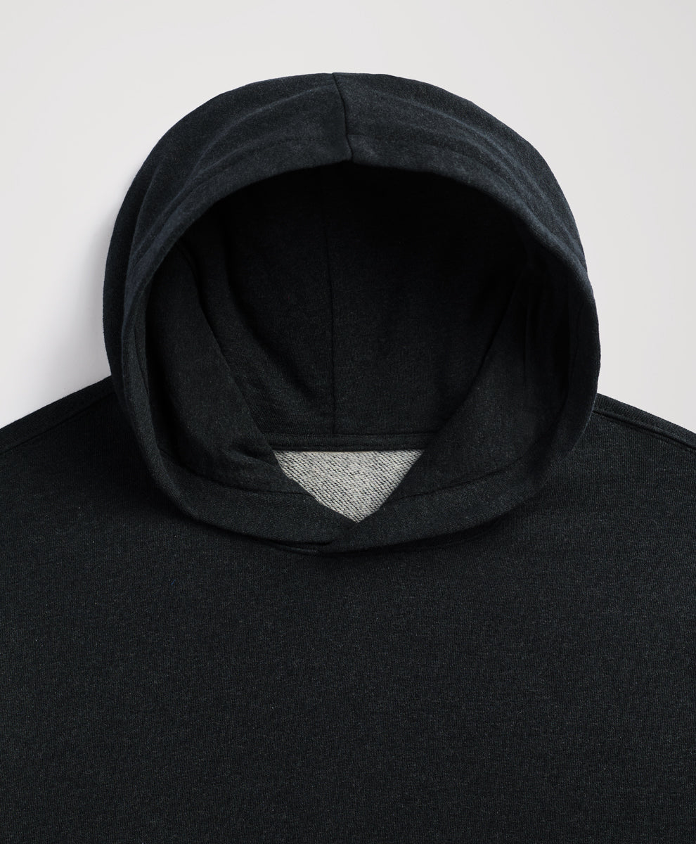 Close-up of a charcoal heather hooded sweatshirt with a contrasting light gray inner lining visible at the opening, shot against a plain light gray background.