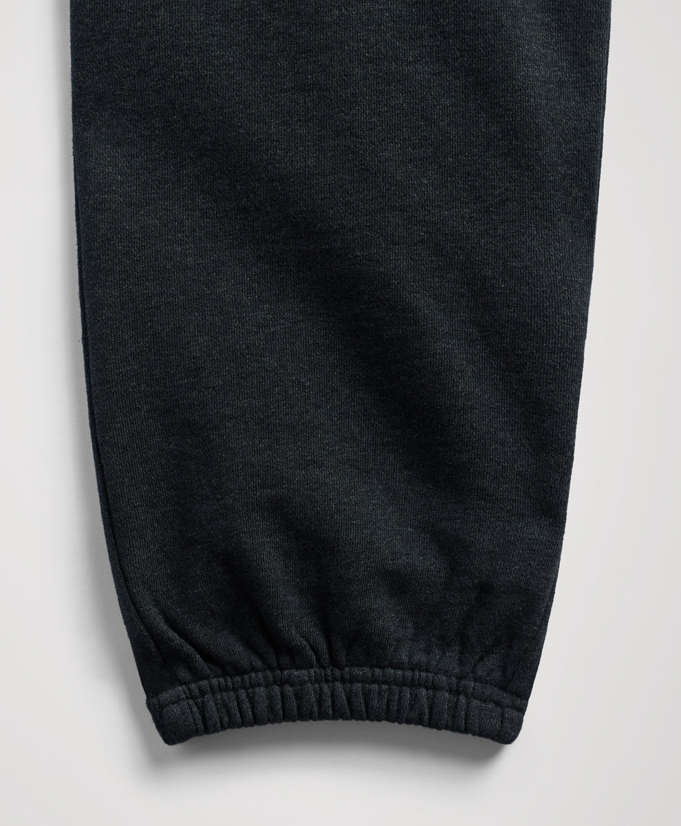 Close-up of a charcoal heather fabric garment, showing a ribbed elastic cuff on a light gray background.