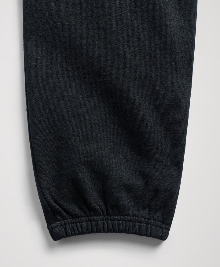 Close-up of a charcoal heather fabric garment, showing a ribbed elastic cuff on a light gray background.