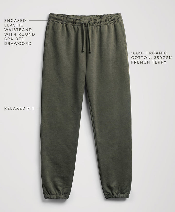 Pact dusted green relaxed-fit sweatpants with a drawstring waistband, shown on a light gray background with text callouts describing features and fabric.