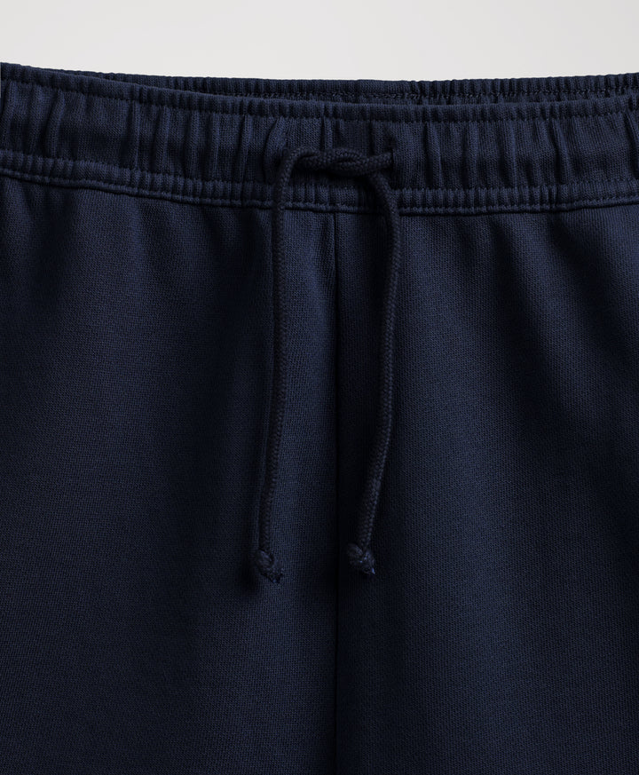Close-up of navy blue sweatpants showing the elastic waistband and matching drawstring.