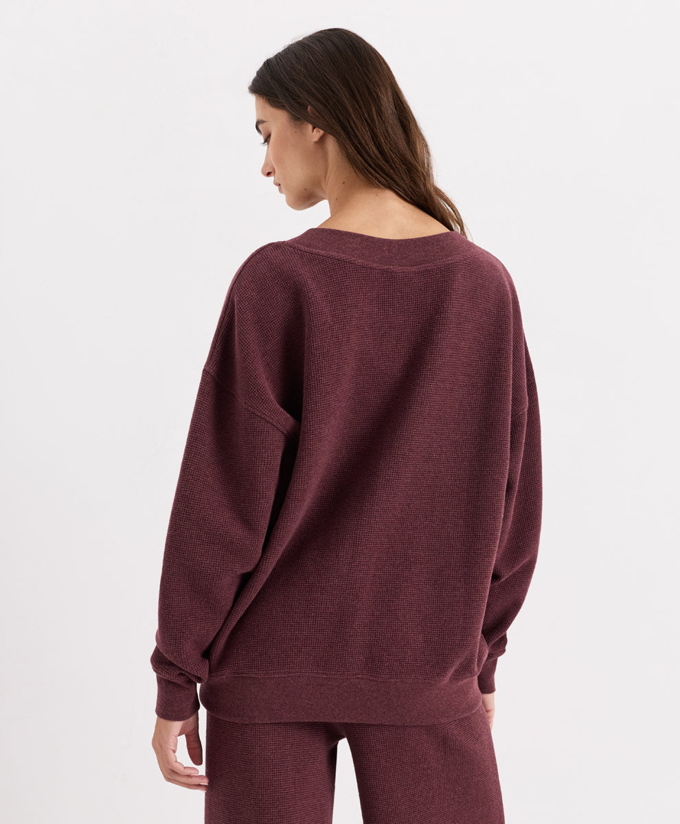 A woman shown from the back wearing an oversized V-neck top and matching sweatpants in merlot heather, set against a plain white studio background.
