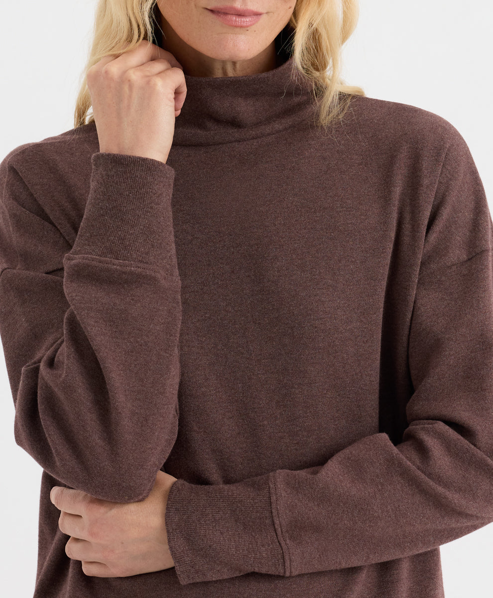 A close-up of a woman wearing a chestnut heather funnel neck top, showing the texture of the fabric and the fit of the long sleeves.