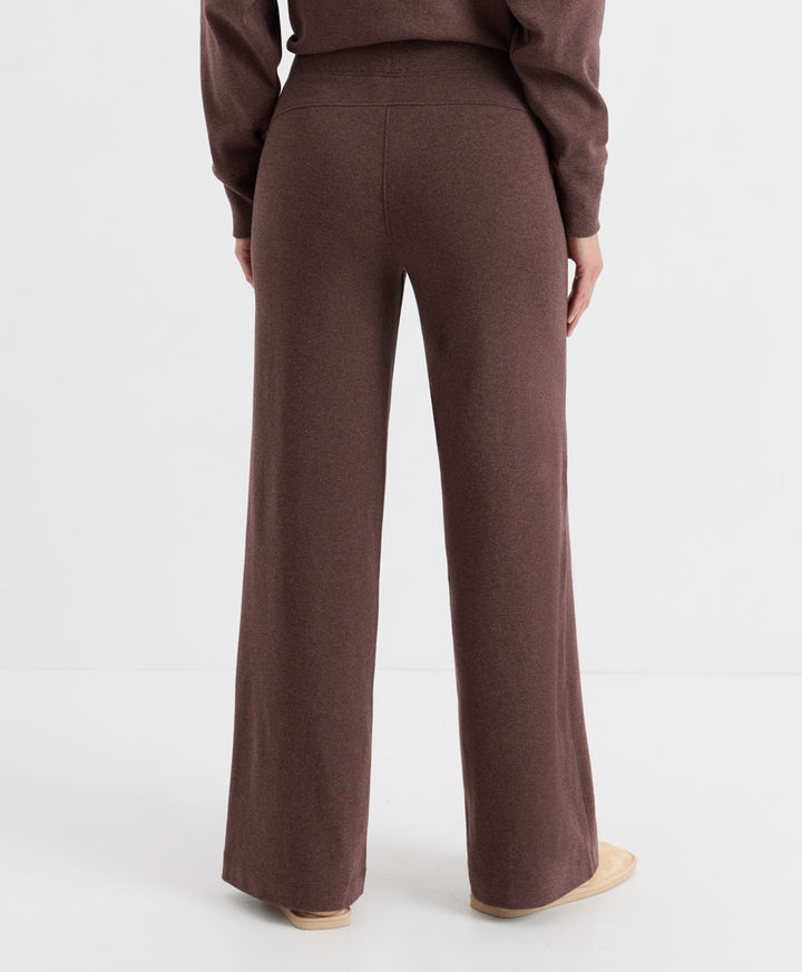 A person shown from the back wearing a matching chestnut heather knit top and wide-leg knit pants, photographed against a clean light gray studio background.