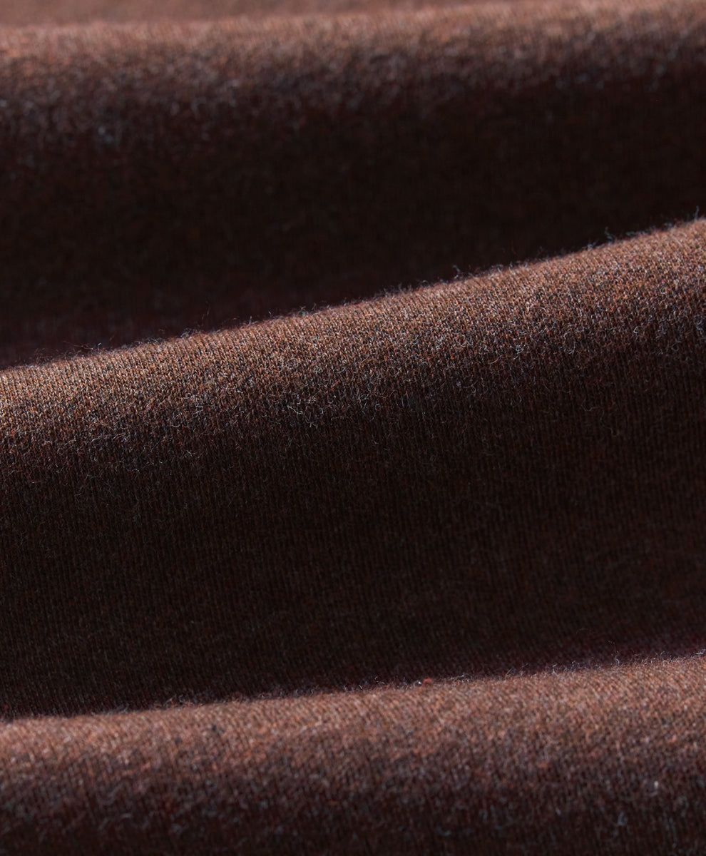 A close-up of draped chestnut heather knit fabric showing its soft texture and fine weave.