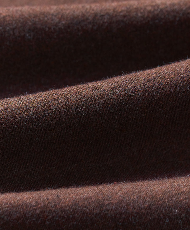 A close-up of draped chestnut heather knit fabric showing its soft texture and fine weave.
