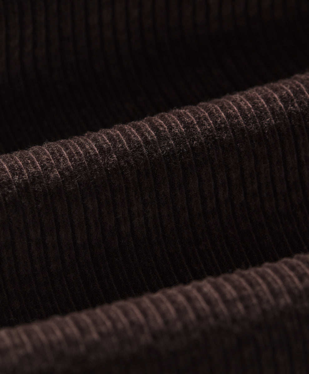 Close-up of a espresso ribbed corduroy fabric texture, showing the detailed vertical ribbing and soft pile.