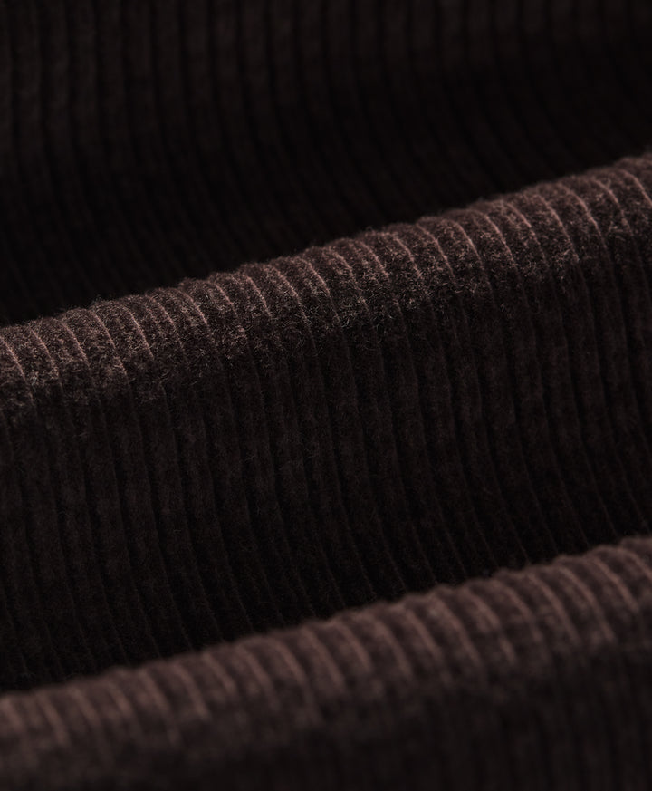 Close-up of a espresso ribbed corduroy fabric texture, showing the detailed vertical ribbing and soft pile.