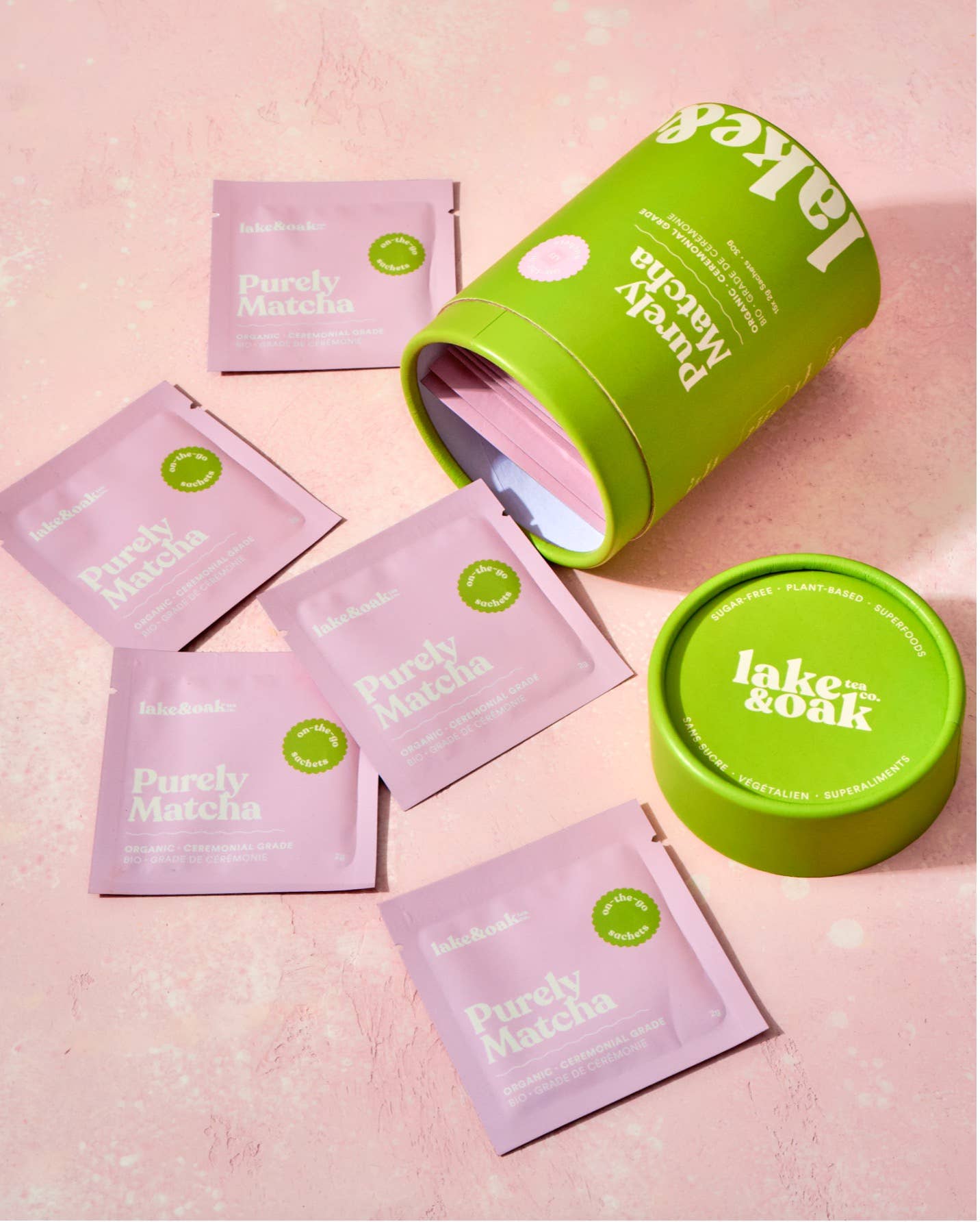 Pink packets labeled 'Purely Matcha' with green containers on a pink background