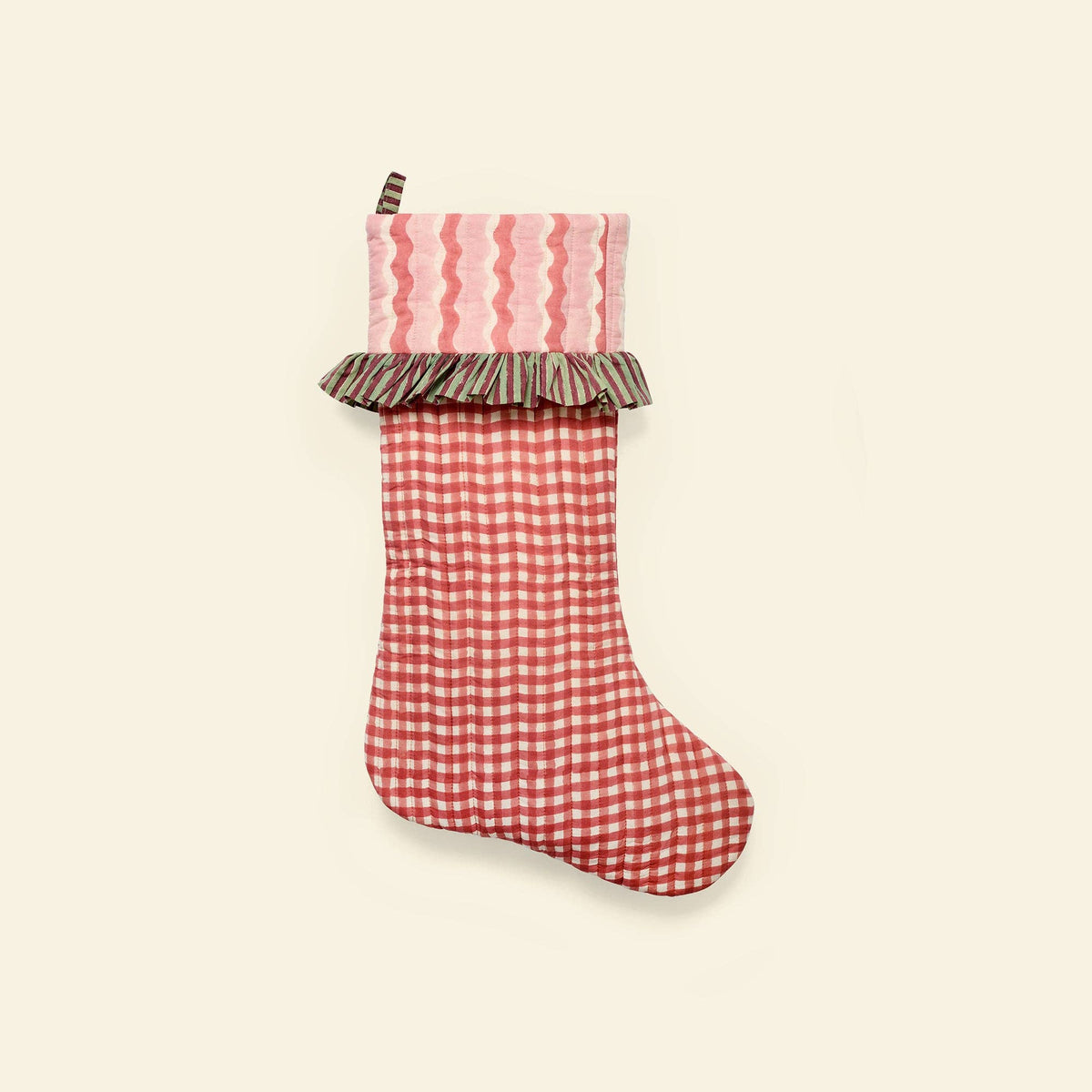 A Christmas stocking featuring a red and white gingham body, a pink and red wavy patterned cuff, and a brown and beige striped ruffle trim, shown against a solid cream background.