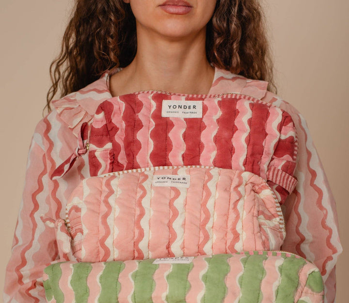 Person wearing a pink and green striped garment with &