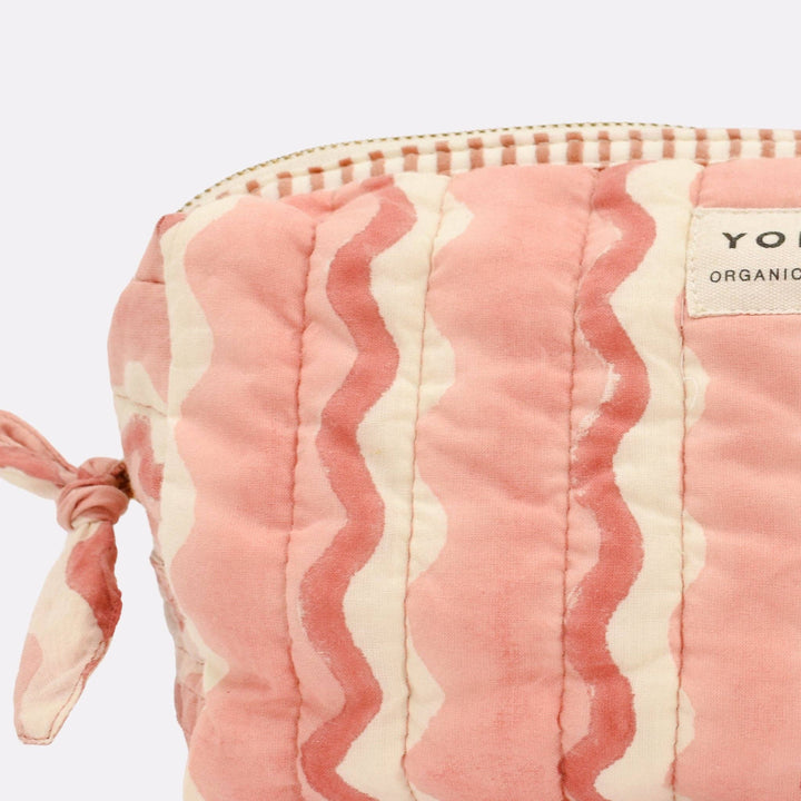 Pink and white striped pouch with a visible brand label on a light purple background