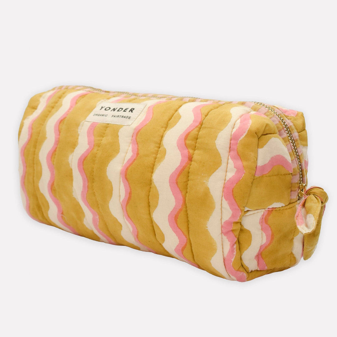 Quilted cosmetic bag with wavy pattern on a white background