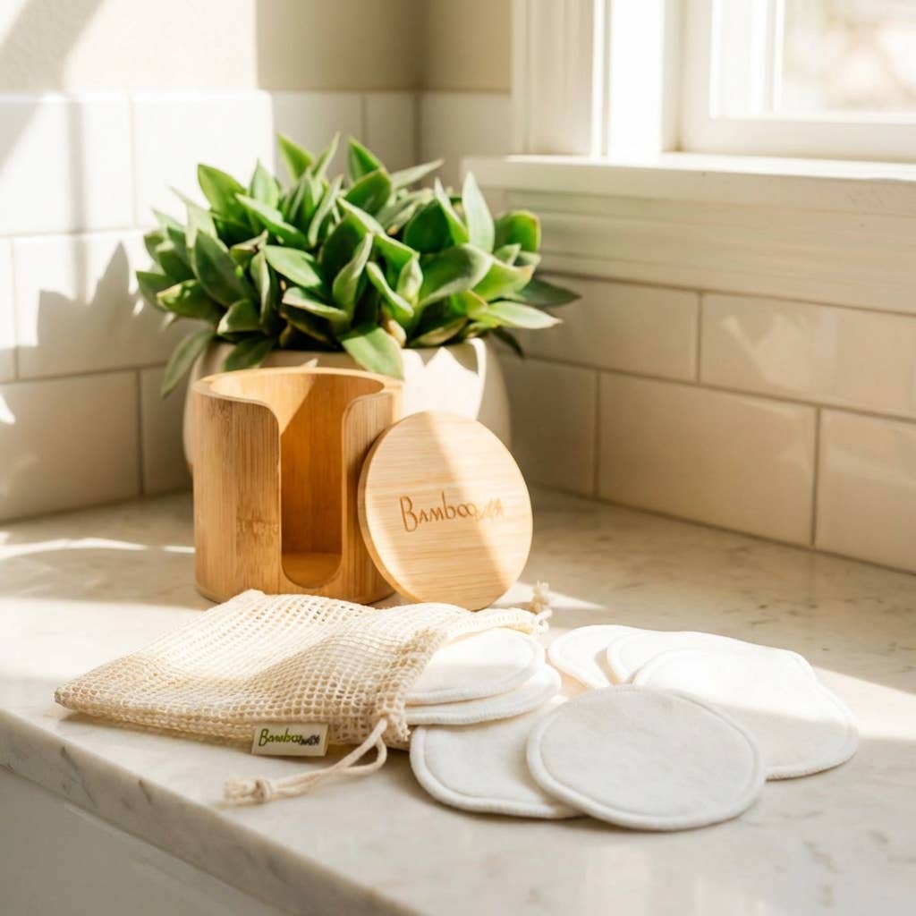Bamboo products including pads and containers on a marble surface with a plant in the background.