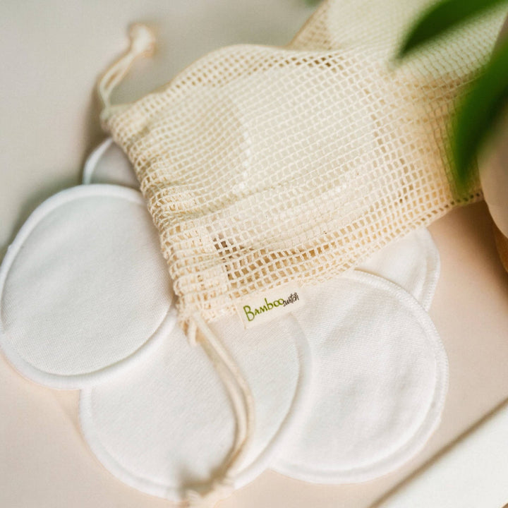 Set of reusable bamboo rounds with a mesh bag on a light background