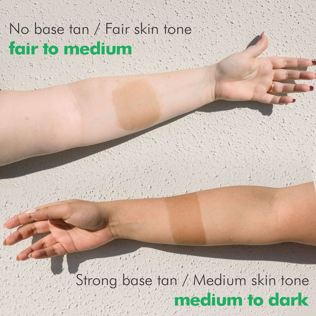 Two arms with different tan shades on a light background