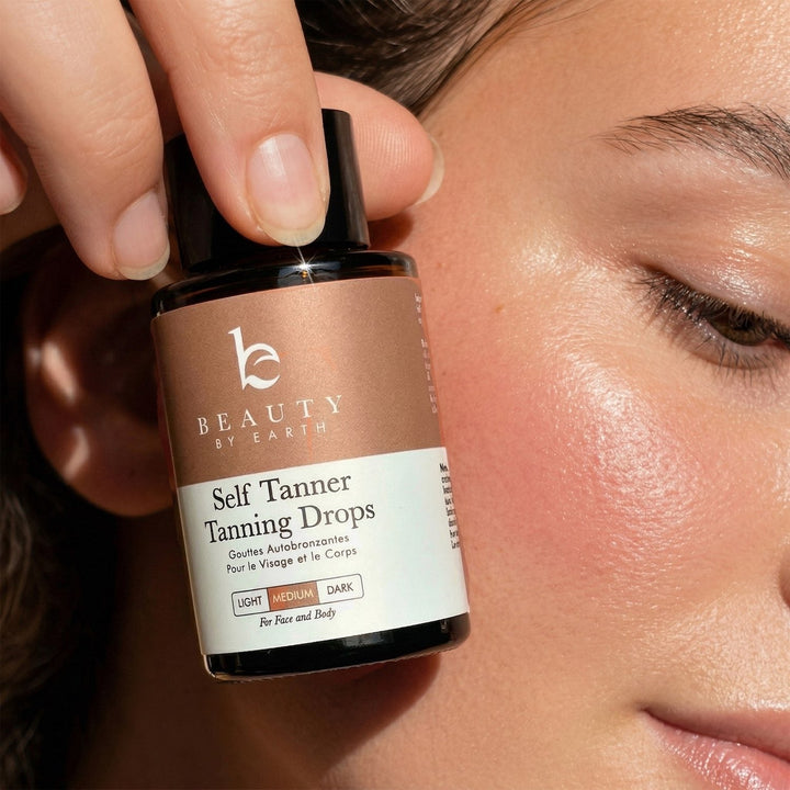 Bottle of Beauty by Earth Self Tanner Tanning Drops held near a person&