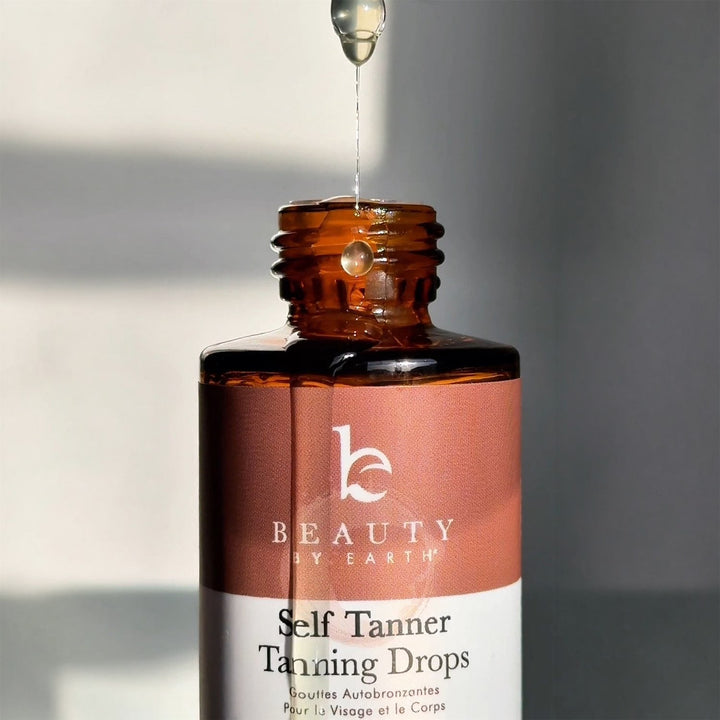 Bottle of Beauty by Earth Self Tanner Tanning Drops with dropper on a neutral background
