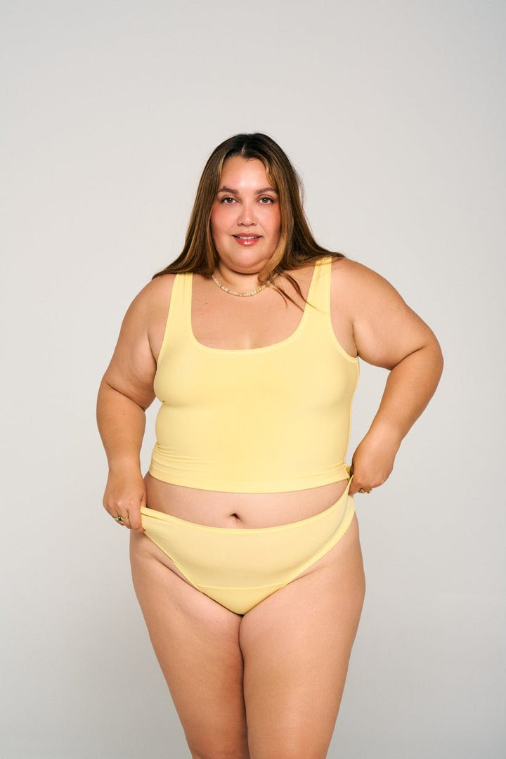 Woman wearing a Limoncello Sporty Crop Tank by Huha on a plain background