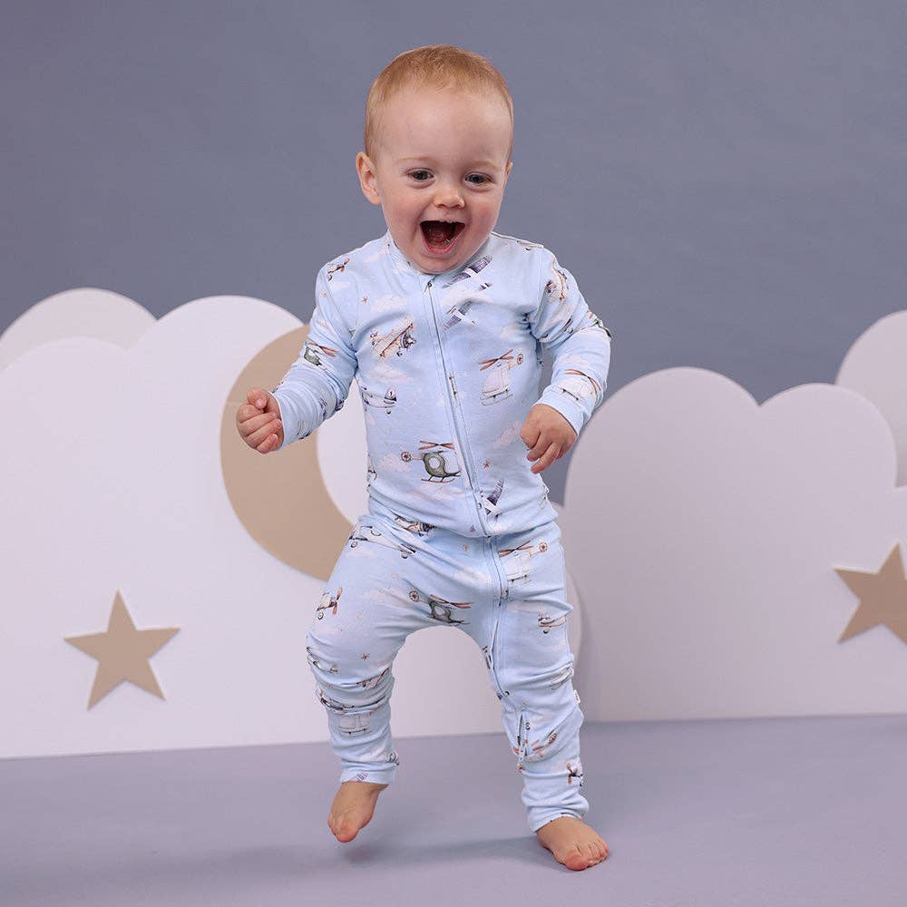 Child wearing a Taking Flight Organic Snugglesuit Convertible Romper against a gray background