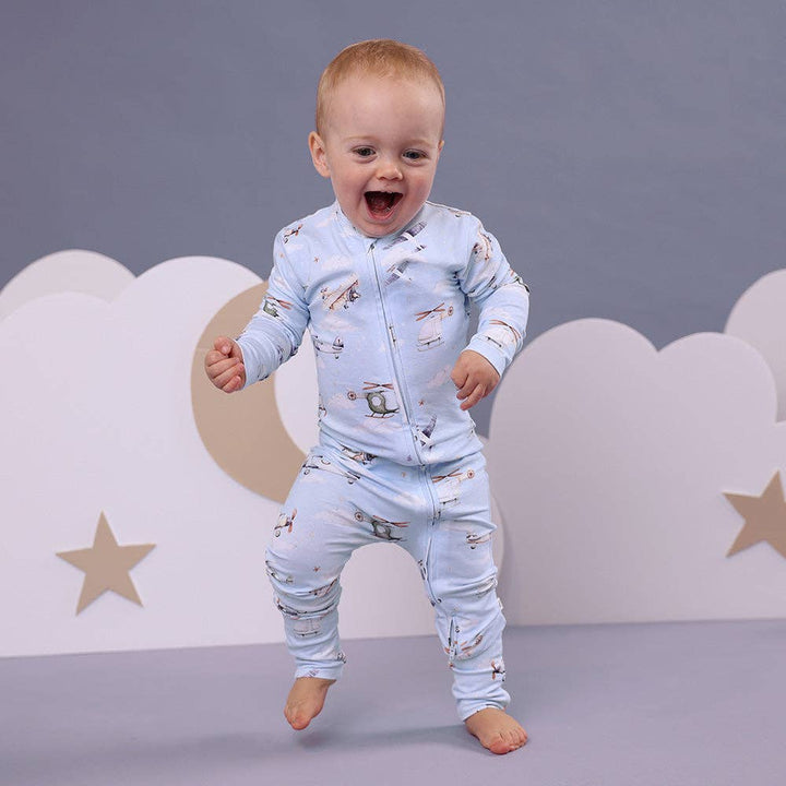 Child wearing a Taking Flight Organic Snugglesuit Convertible Romper against a gray background