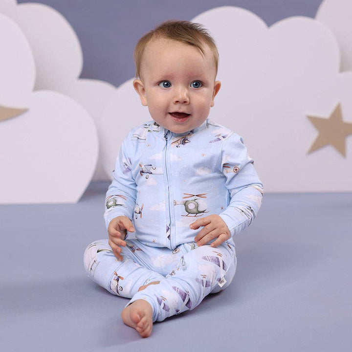 Child wearing a Taking Flight Organic Snugglesuit Convertible Romper against a gray background
