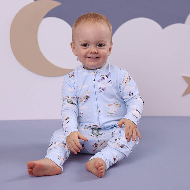 Child wearing a Taking Flight Organic Snugglesuit Convertible Romper against a gray background