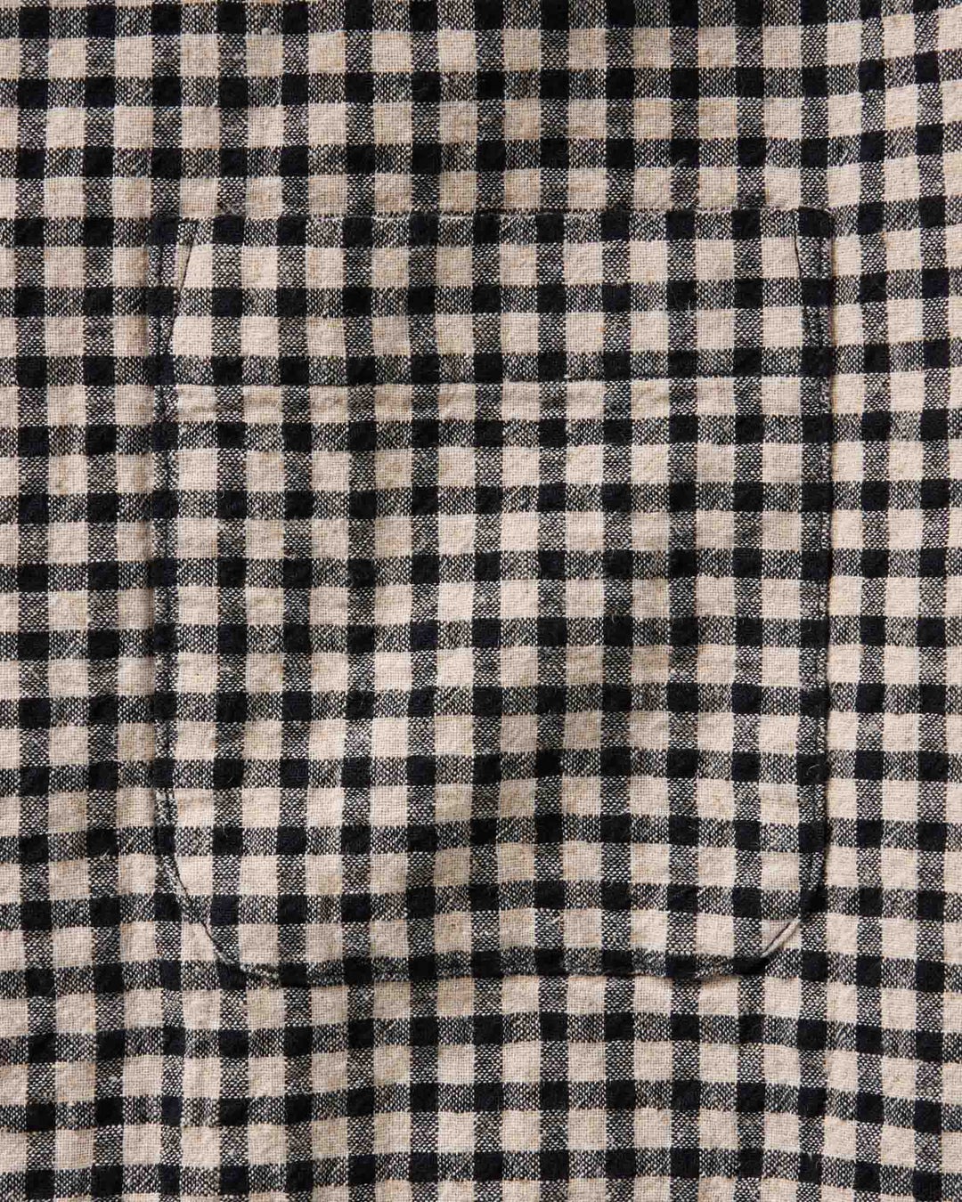 Close-up of The California Shirt in Breaker Gingham fabric with a single curved welt pocket stitched into the lower left area.