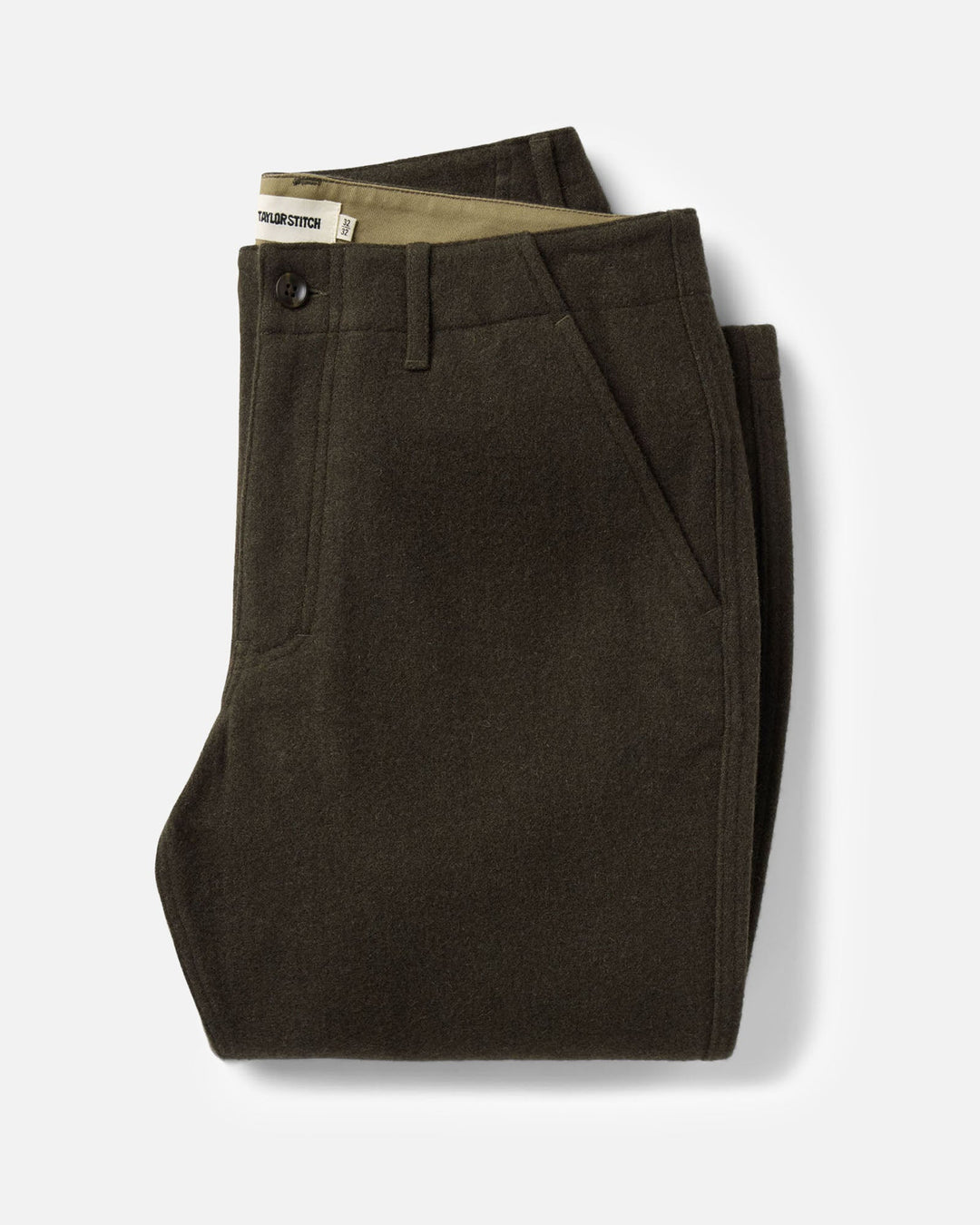 Flat lay of a pair of folded carnegie pants in army wool on a white background.