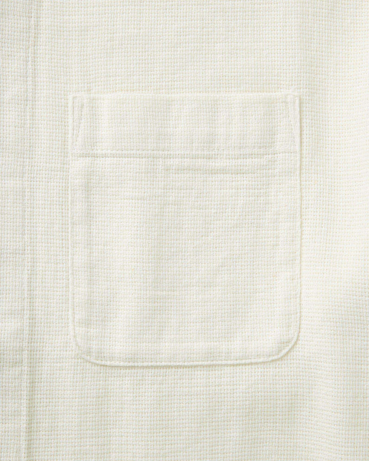 Close-up of a textured white fabric with a pocket
