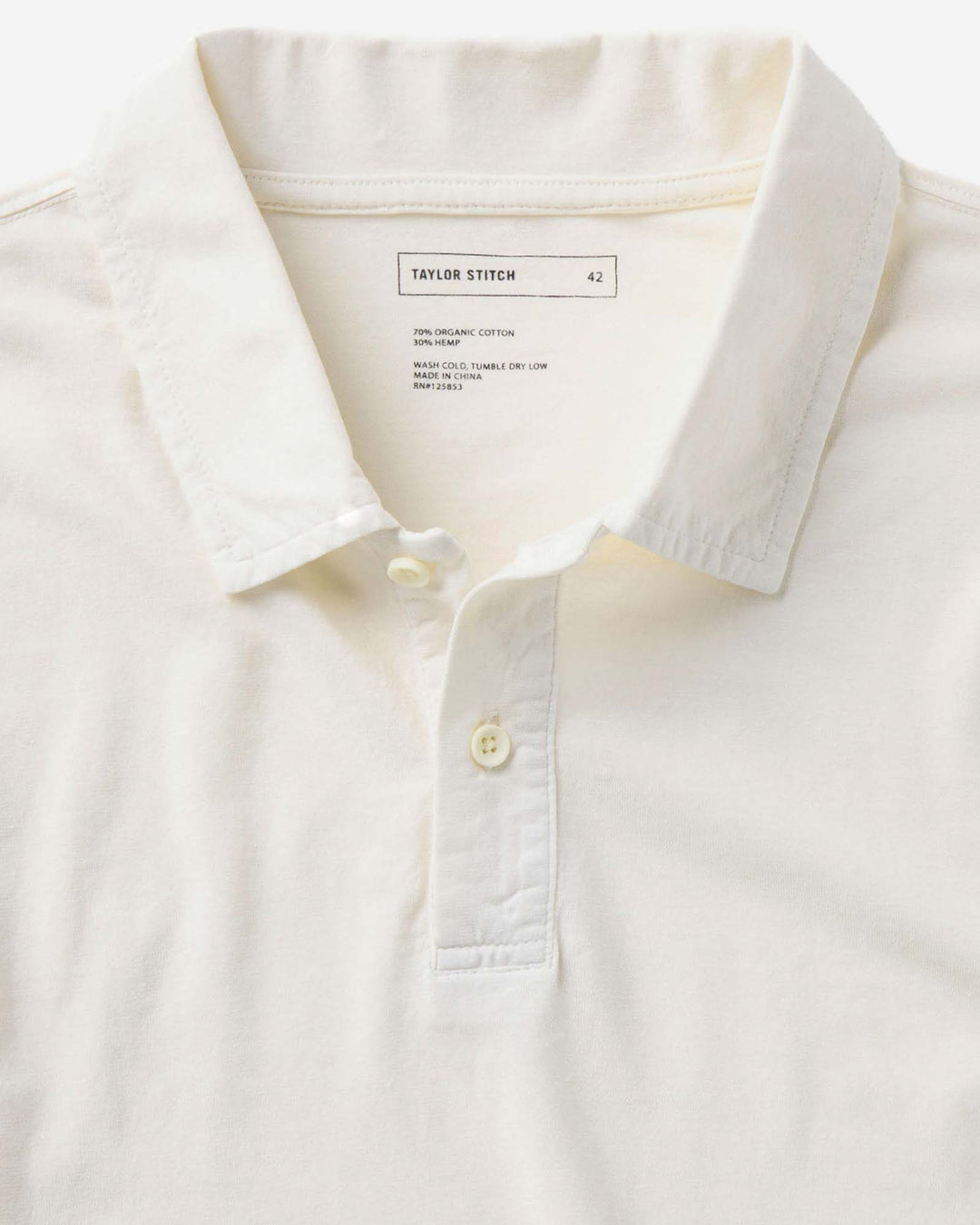 Close-up of The Cotton Hemp Polo in Vintage White with collar and button details, featuring &