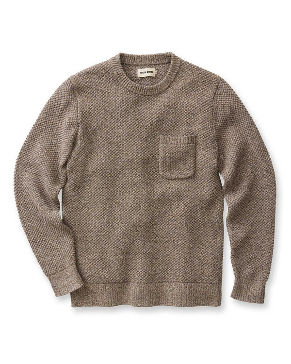 A man wearing Crawford Crew Sweater in Coffee Twist with a chest pocket, against a white backdrop.