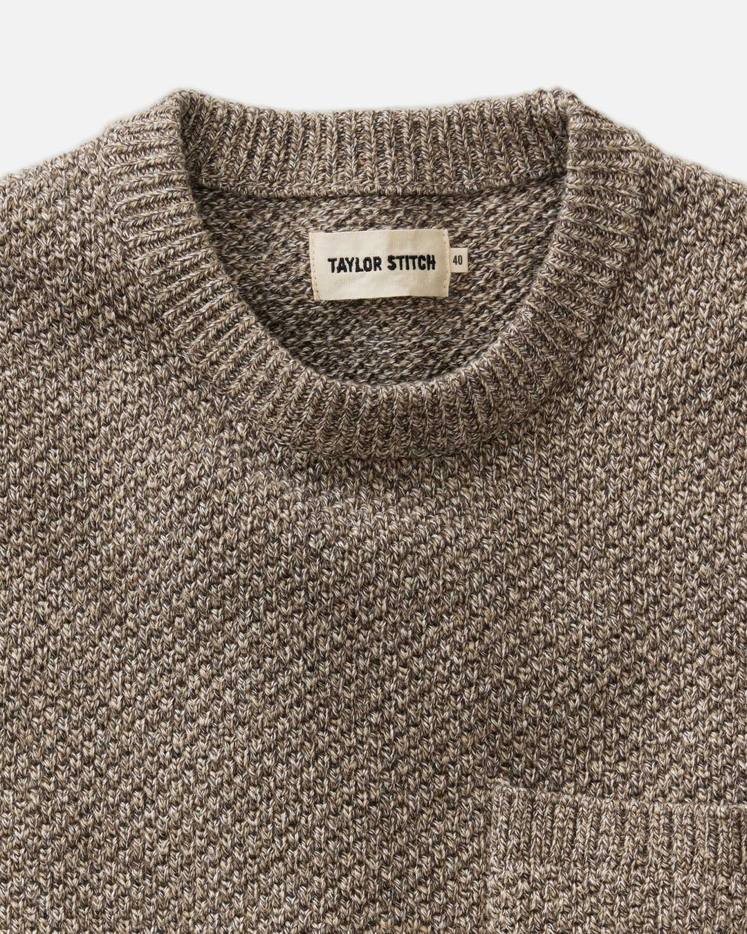 Close-up of The Crawford Crew Sweater in Coffee Twist showing the ribbed crew neck and a white Taylor Stitch brand label.
