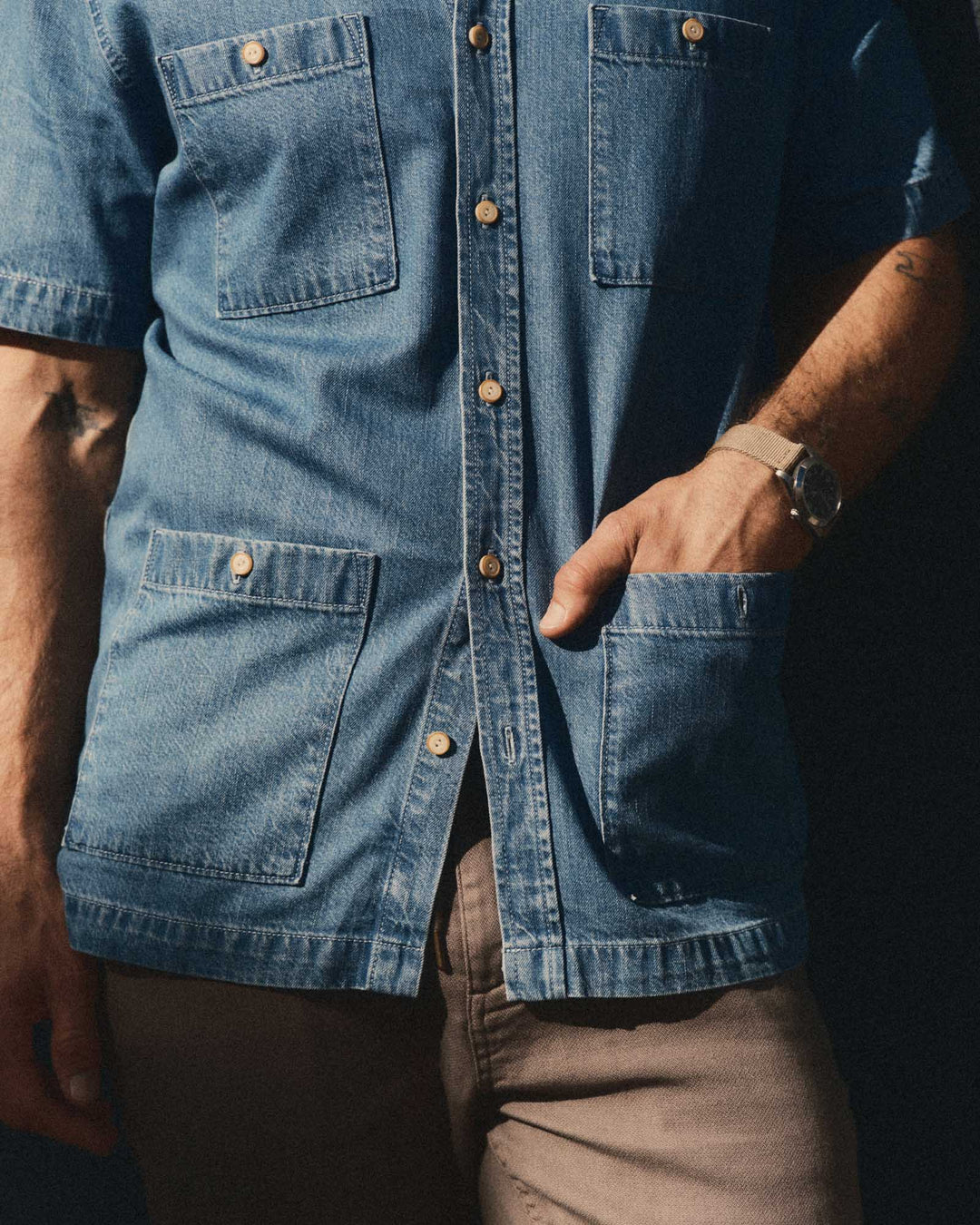 Close-up of a person wearing The Gulf Shirt in Washed Indigo Twill with visible buttons and pockets.