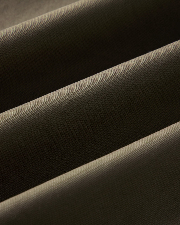 Close-up of draped fabric with a fine woven texture in a dark olive color.