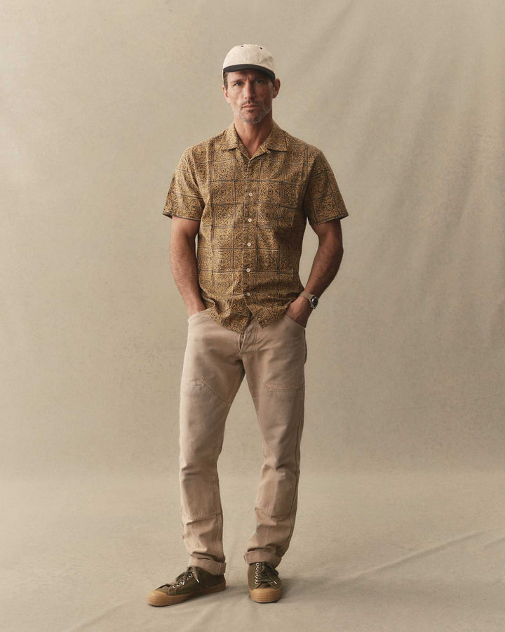 Man wearing The Hawthorne Shirt
in Fennel Block Print and beige pants standing against a plain background