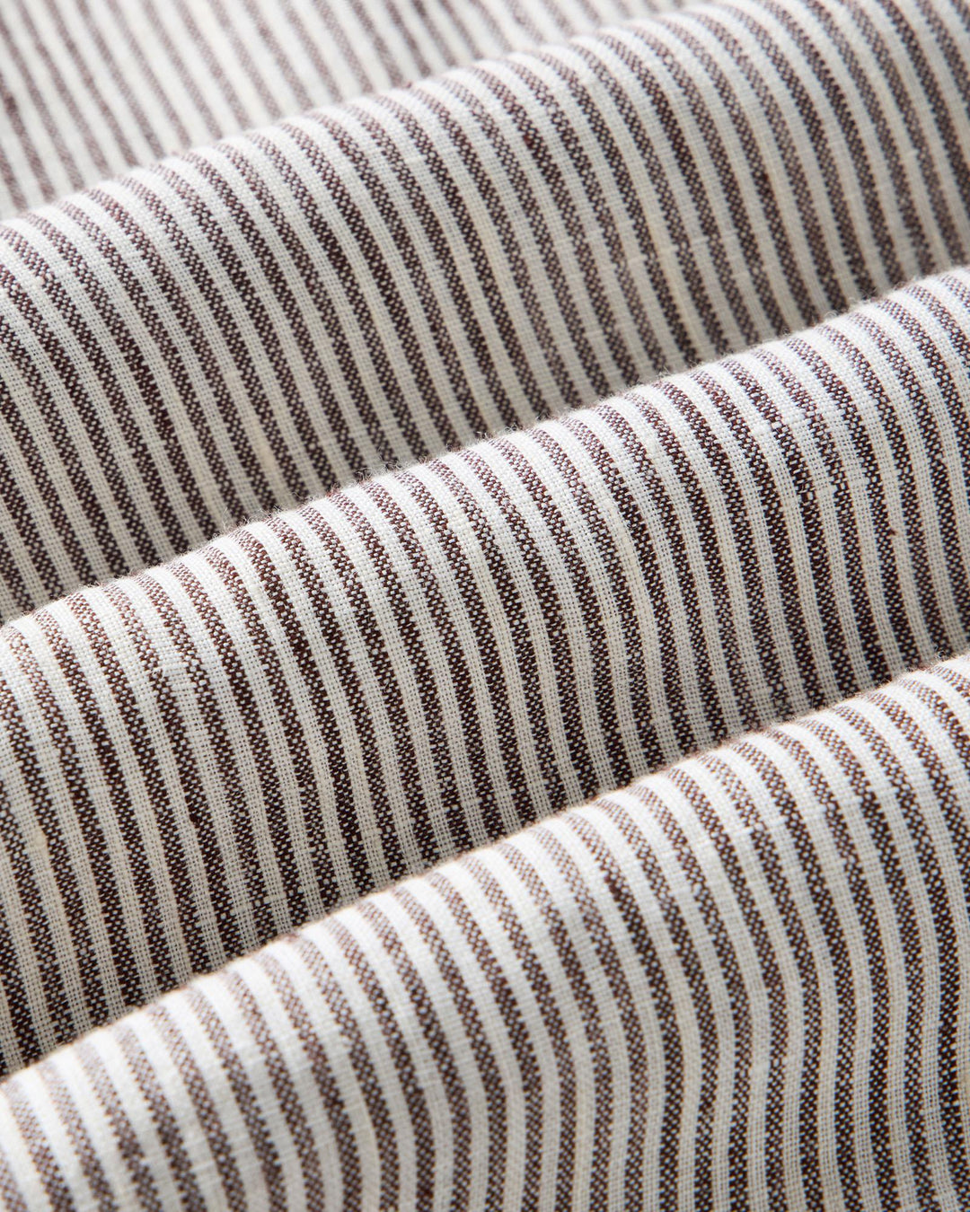 Close-up of Burgundy University Stripe Linen fabric with brown and white lines.