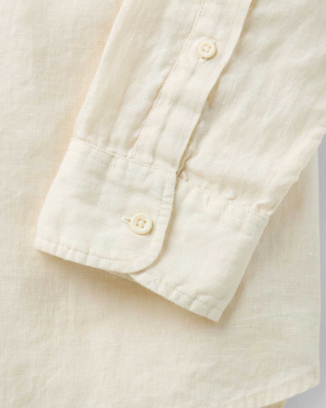 Close-up of a vintage white-colored shirt with buttons on a light background