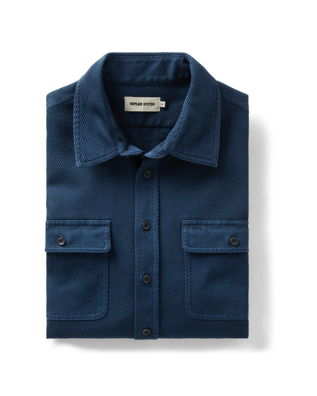 A folded navy blue textured button-down shirt with two chest flap pockets, displayed on a clean white background.