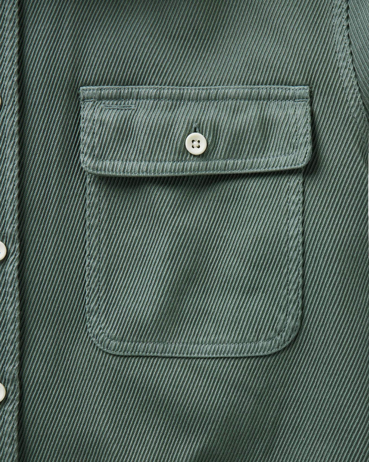 Close-up of a ledge deep sea shirt jacket showing a chest pocket with a button flap and a silver snap button.