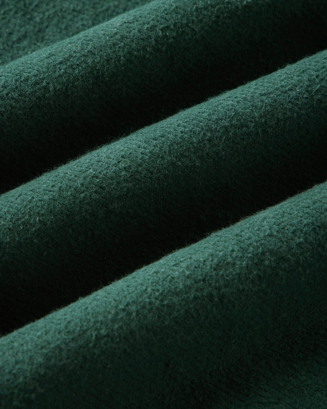 A close-up of dark forest green textured fabric.