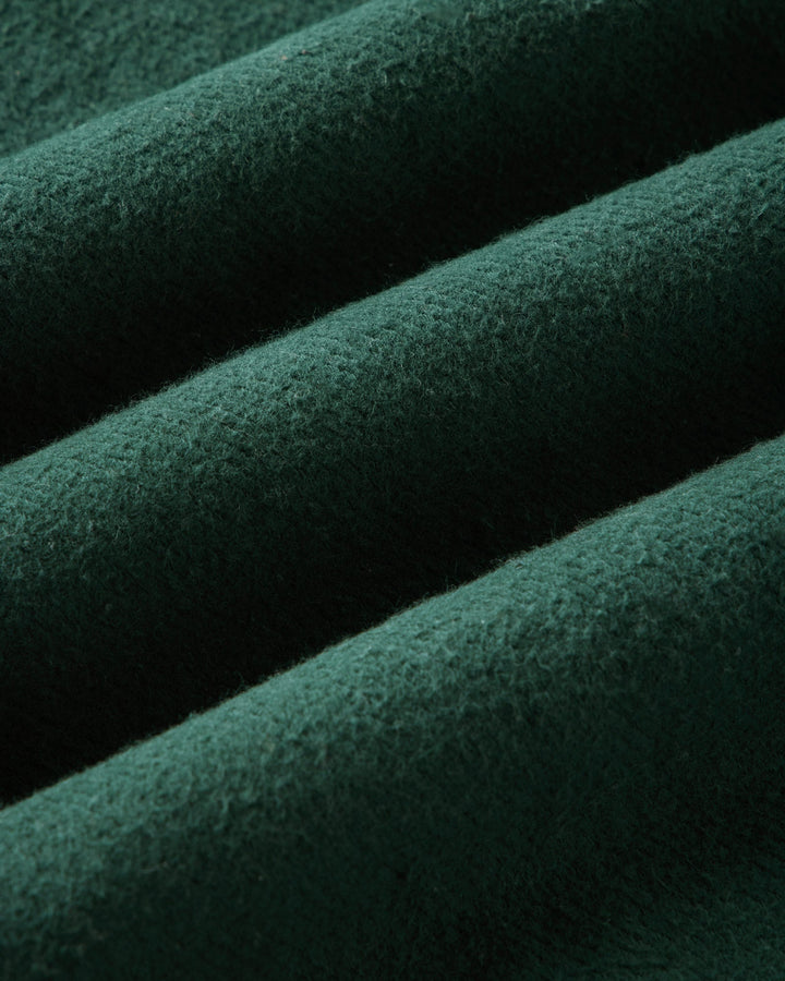 A close-up of dark forest green textured fabric.