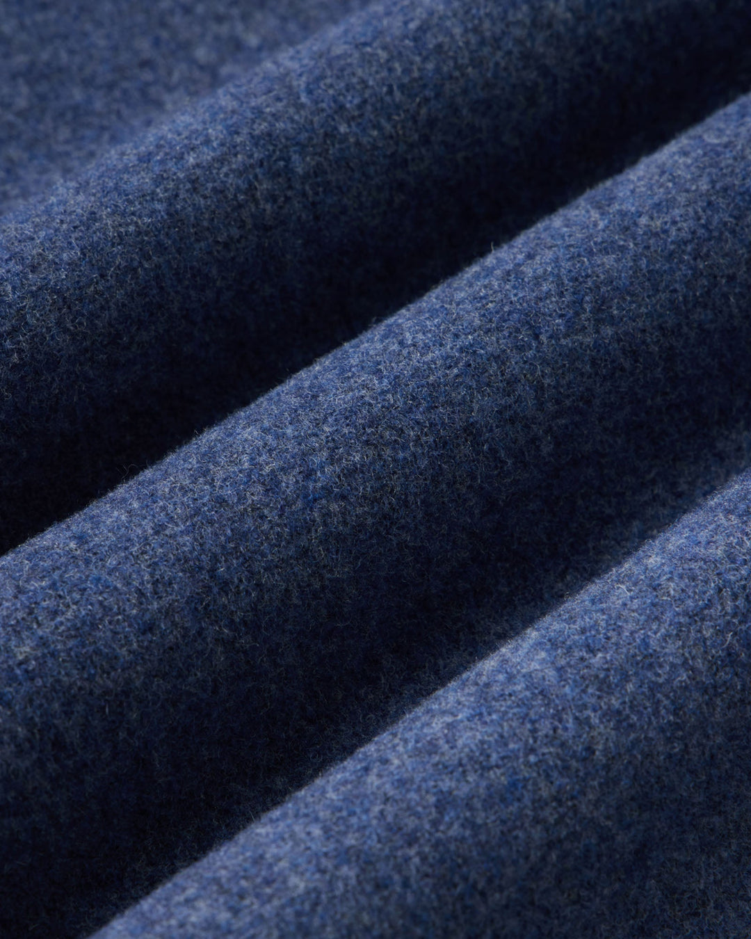 A close-up of folded navy blue wool fabric showing its soft, textured surface.