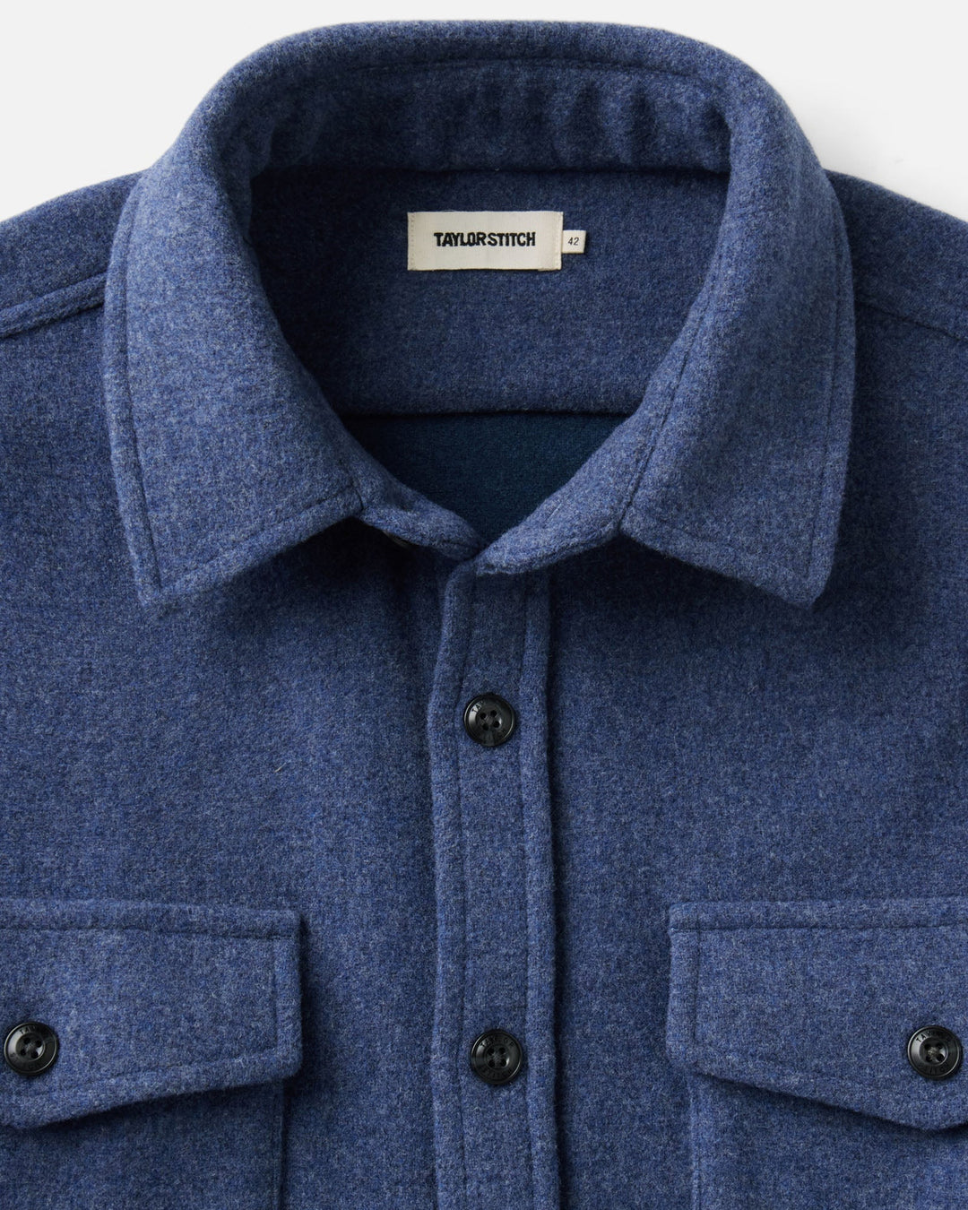 Close-up of The Maritime Shirt Jacket
in Heather Navy Wool with a collar, dark buttons, and a visible &