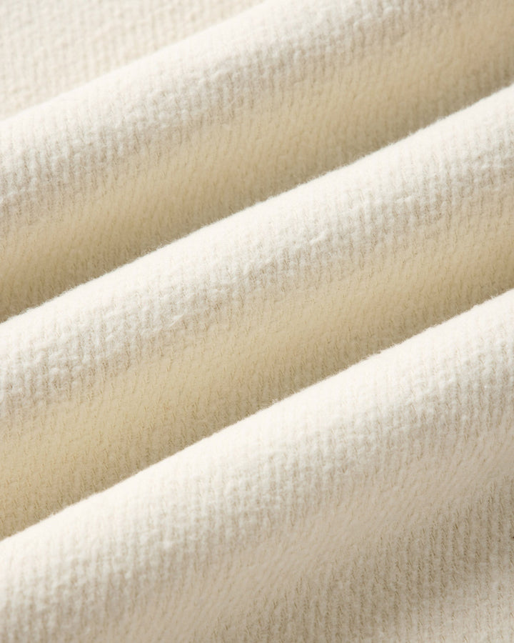A close-up of draped vintage white-colored fabric with a soft, textured surface.