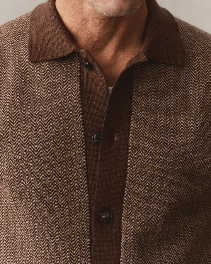 Close-up of a man wearing The Miles Sweater Polo in Espresso Merino with a solid brown collar and button placket.