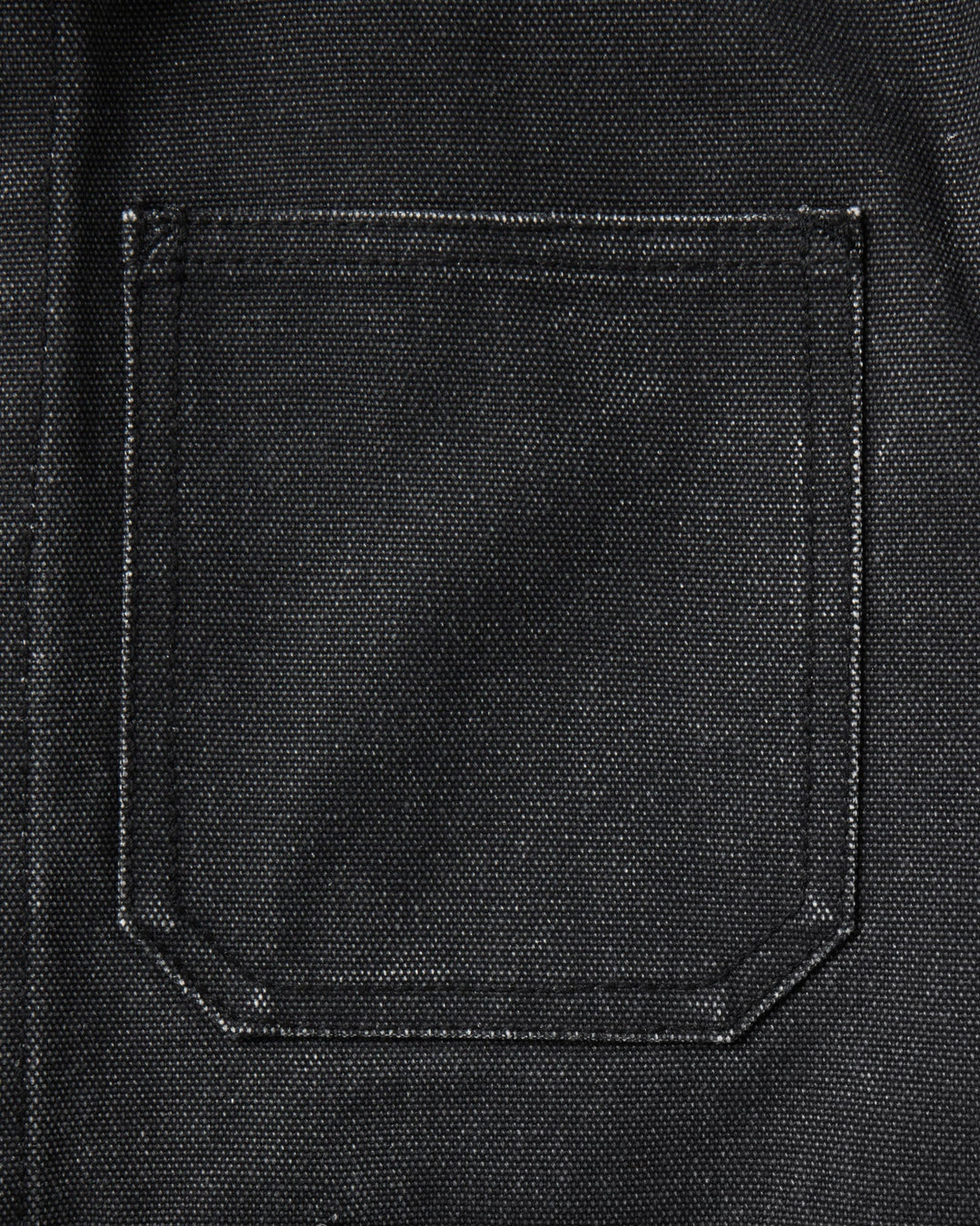 Close-up of a black canvas or heavy fabric pocket with visible stitching and a coarse woven texture.