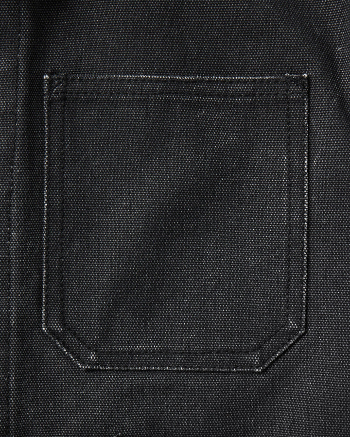 Close-up of a black canvas or heavy fabric pocket with visible stitching and a coarse woven texture.