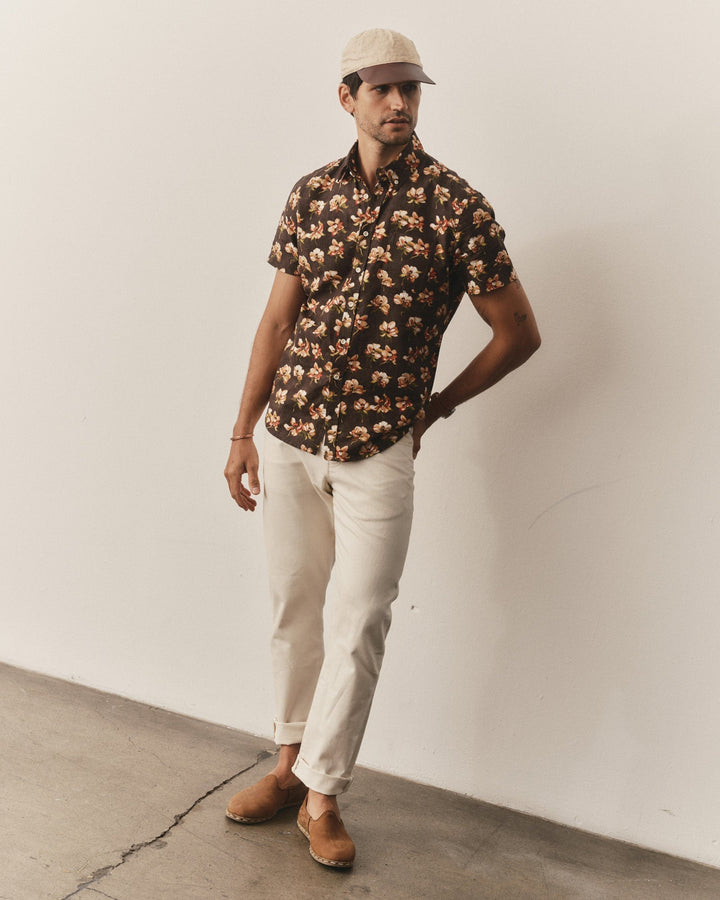 Man wearing The Short Sleeve Jack
in Magnolia, white pants, and a cap against a plain wall.